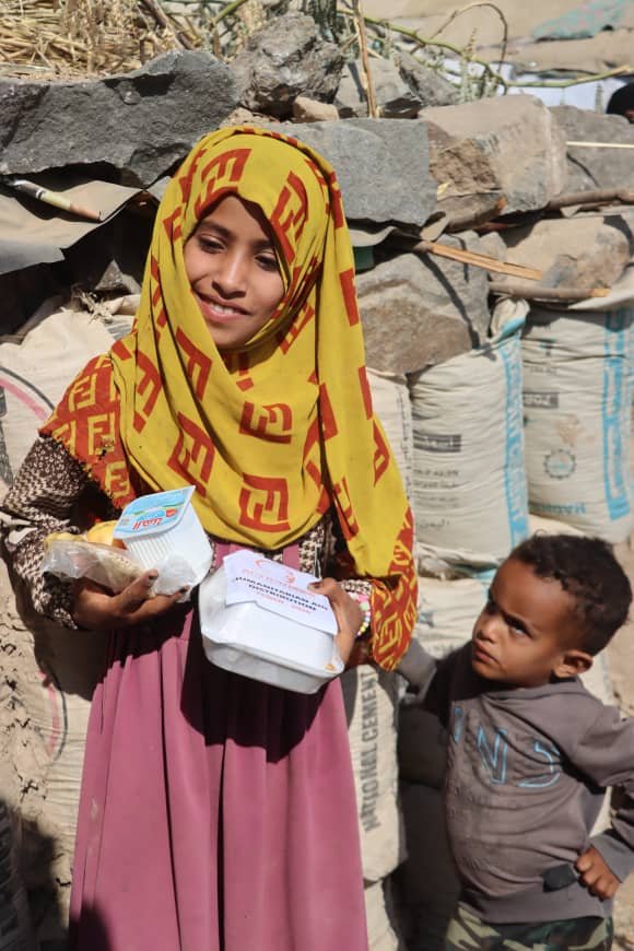 A smiling girl with her family's meals